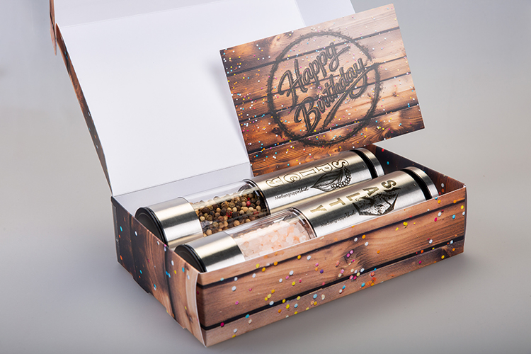 Ein Salzstreuer und ein Pfefferstreuer in einer Geschenkbox mit einer Karte