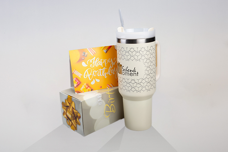 Ein individueller Trinkbecher mit einer Karte und Geschenkbox
